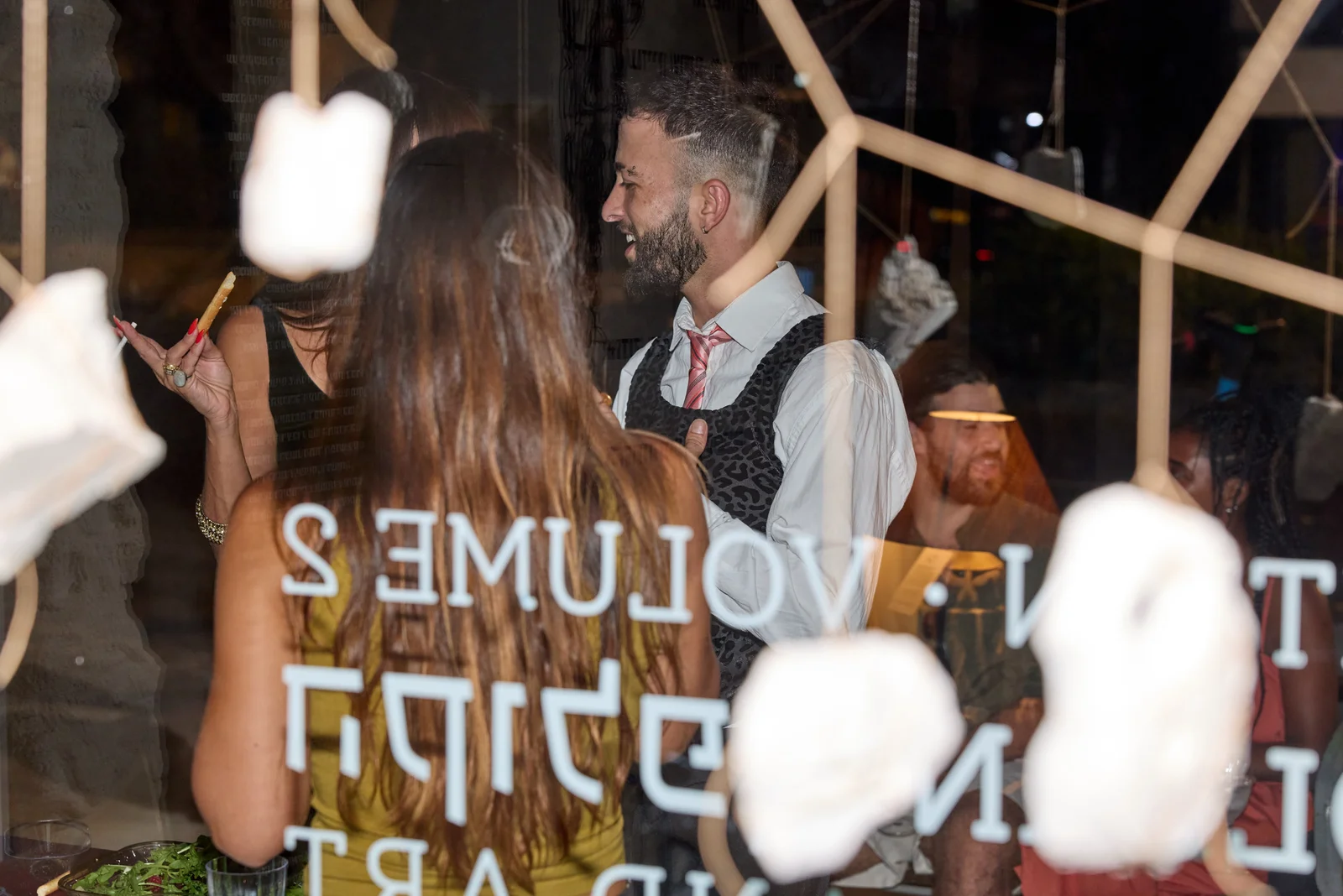 שני משתתפים משוחחים ליד חלון הראווה של תערוכת הקולפן