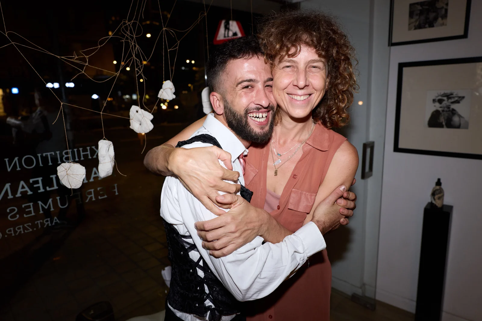 שני משתתפים מחובקים בחלל הגלריה בערב האירוע