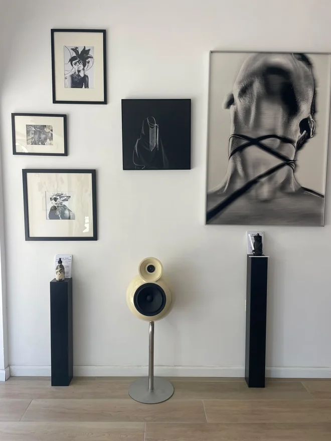 רמקול פיסולי של soos.sound מול קיר עבודות בגלריה